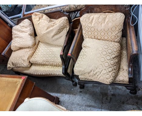 An early 20th century mahogany Bergere two-seater sofa on claw feet, together with a matching armchair 