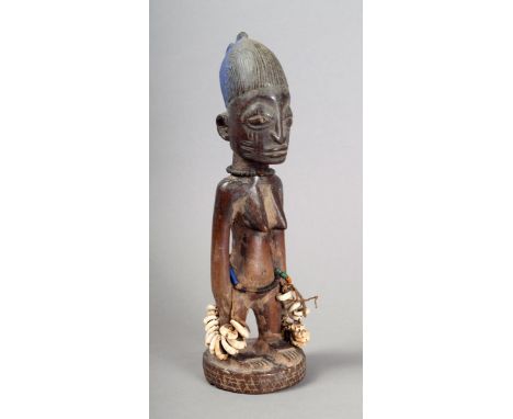A Yoruba Ibeji female figure Nigeria with remains of Reckitt's blue to the double dome crested coiffure, with scarifications 