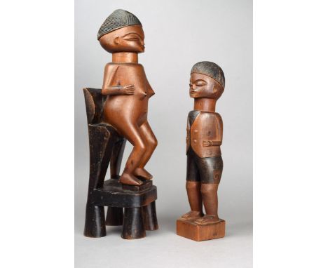 Two Lwena figures Angola carved wood with black staining, female and male; the female with an angled linear coiffure and sitt