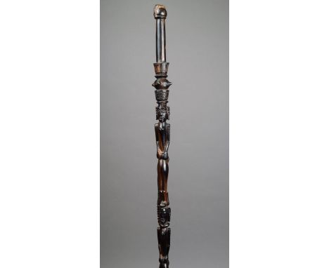An East African walking cane ebony, carved with three figures with snakes coiled around their bodies and with a crested finia
