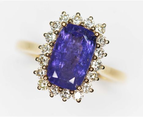 A tanzanite and diamond cluster ring, the central rectangular cushion cut stone weighing approx. 2.66 carats, surrounded by e