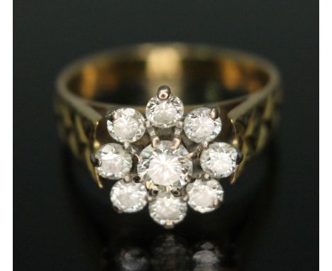 A nine stone diamond cluster ring, the cluster measuring approx. 11.96mm in diameter, engraved shoulders, the band marked 'c1