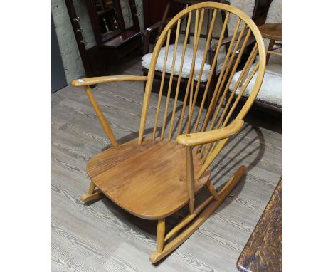 An Ercol light beech and elm rocking chair.Possibly been refinished. The joints to the left arm are loose front and back.