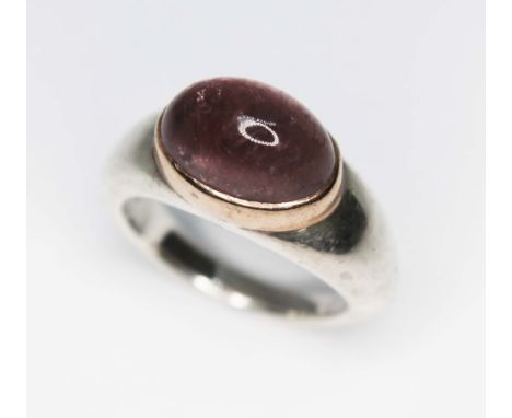 A contemporary silver ring set with an oval amethyst cabochon, sponsor's mark 'GL', London 1998, gross wt. 9.82g, size L.  Co