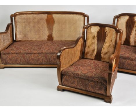 A WALNUT FRAMED BERGERE SUITE comprising a two seater sofa and a pair of matching armchairs with re-upholstered loose cushion