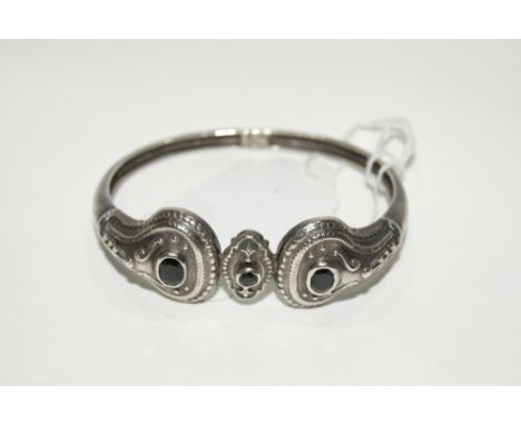 A GREEK SILVER BANGLE with relief stylised form with blue hardstone decoration