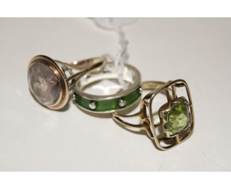 A SILVER ETERNITY RING with green enamel setting, together with a further peridot ring of stylised setting and a 19th Century