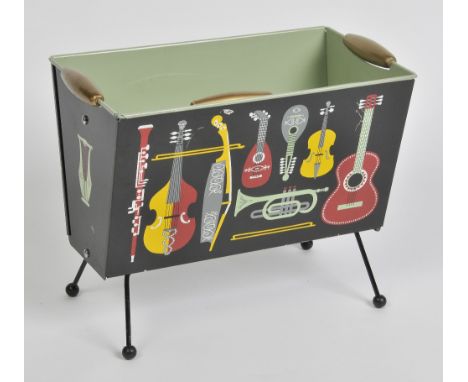 A 1950S WORCESTER WARE MODERNIST METAL MAGAZINE RACK decorated with musical instruments, 33cm high, 42cm across