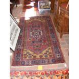 A Middle Eastern rug with geometric border and red