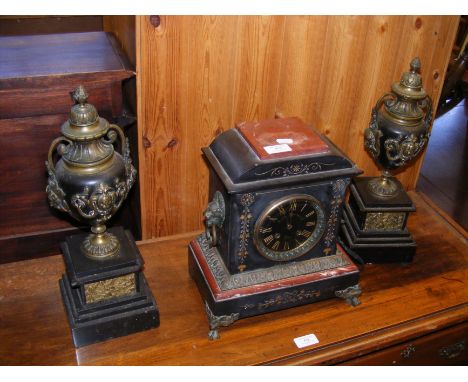 A Victorian slate and marble mantel clock with side garnitures 
