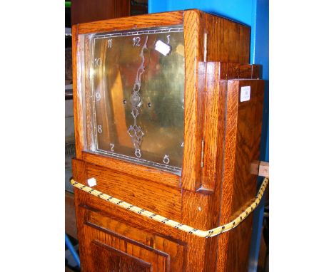 A brass faced oak cased Art Deco Grandfather clock with accessories 