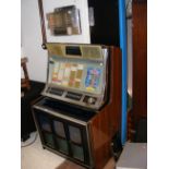 A vintage Rock-Ola juke box with wall mounted remo