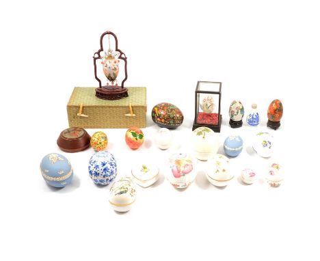 A collection of egg ornaments and trinket boxes, to include a Chinese glass egg, reverse painted, suspended from a wooden fra