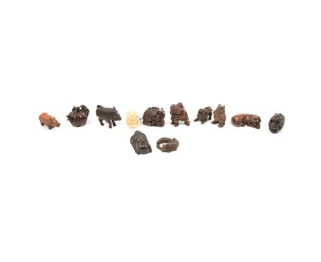 Collection of eleven carved wooden netsukes inlcuding three dragons, temple dog, tiger, rhinocerous, owl, boar, goddess mask,