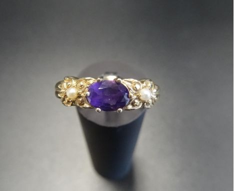 AMETHYST AND SEED PEARL DRESS RINGthe central oval cut amethyst flanked by seed pearl set moulded shoulders, in nine carat go