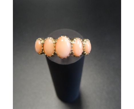 GRADUATED CORAL FIVE STONE RINGon nine carat gold shank with decorative shoulders, ring size N 