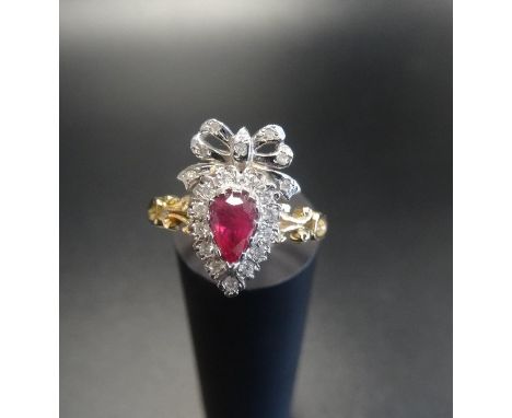 UNUSUAL RUBY AND DIAMOND CLUSTER RINGthe pear cut ruby in diamond surround and surmounted by a diamond set bow, on nine carat