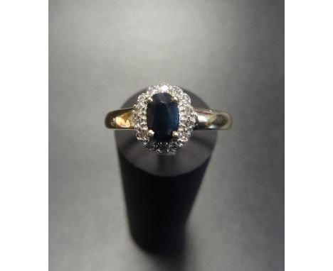 SAPPHIRE AND DIAMOND CLUSTER RINGthe central oval cut sapphire in diamond surround, on nine carat gold shank, ring size N 