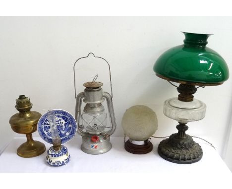 EDWARDIAN OIL LAMPraised on a circular embossed base to a glass reservoir, stack and green glass shade, 48cm high, a brass bo