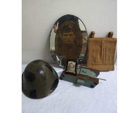 MILITARY INTERESTa WWII canvas map holder, a WWI oval wall mirror with a photographic print of a soldier, an army metal helme