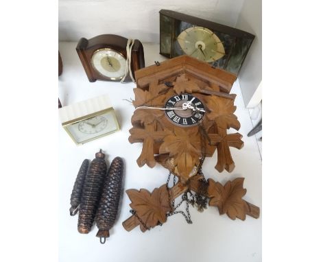 BLACK FOREST CUCKOO CLOCKwith carved oak leaf decoration around the circular dial with Roman numerals above metal pine cone w