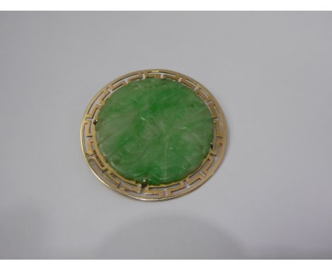 A Chinese Apple Green Jade Disc Brooch, the brooch carved with flowers and in 14 ct gold stylized mount, approx 3.5 cms, appr