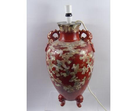 A Japanese Satsuma Lamp Base, on tripod base, decorated with Buddhist symbolism on red glazed ground, supported on Imperial L