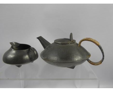 A Hammered Pewter Creamer and Tea Pot, the teapot stamped 0231 to base and English pewter made by Liberty & Co.