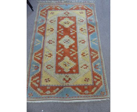 A Woollen Persian Style Carpet, of geometric design with three central guls, orange, blue and gold colouring, approx 124 x 20