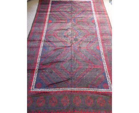 An Afghan Mushwani Baluch Carpet, comprising jewel colours of blue, claret and green with graded diamond motifs, approx 307 x