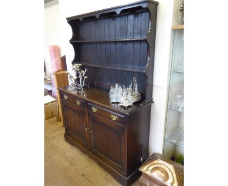 A Dark Oak Vintage Dresser, the dresser having two plate racks with two drawers and cupboards under.