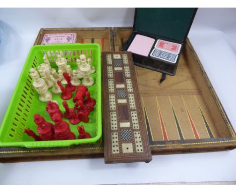 An Antique Backgammon, Chess and Drafts Folding Board, together with bone chess pieces, B.P Grimaud playing cards, mother-of-