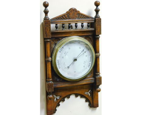 An Edwardian walnut cased wall barometer, the 20cm Dia. dial in a heavily carved case.