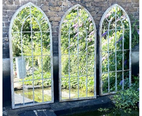 ARCHITECTURAL GARDEN MIRRORS, set of three, 160cm high, 67cm wide, Gothic style with overlaid glazing bars, painted distresse
