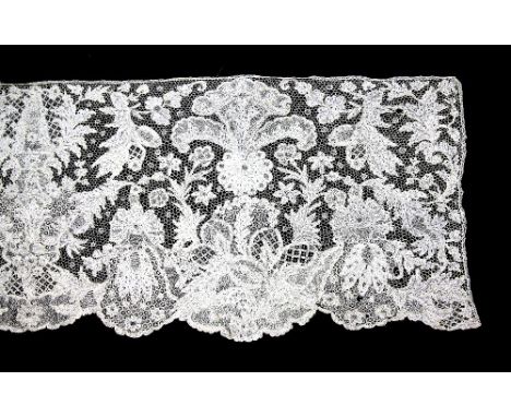 A Fine border of Brussels needle lace with complex Rococo  design of large scale leaves and flowers shells and fruit and a nu