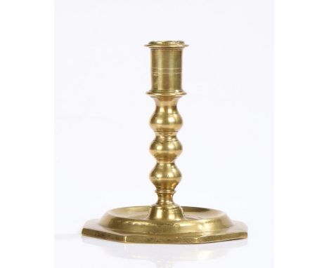 Spanish late 17th Century brass candlestick, the turned stem above a wide octagon foot, 13cm high
