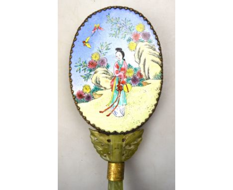 An oval mirror with Canton style enamel back, decorated with a high ranking lady in a garden; the handle in bowenite or other