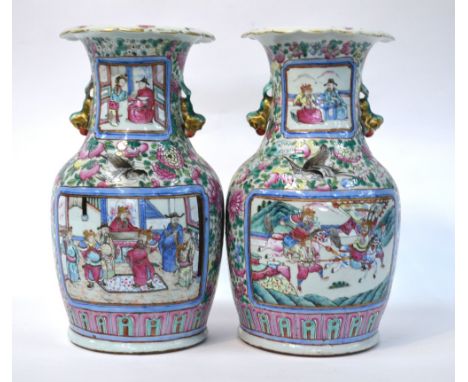 A pair of Canton famille rose vases; each one decorated with narrative scenes of scholars or Bannermen on a floral ground bes
