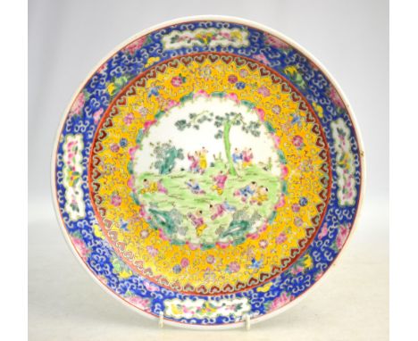 A famille rose dish, decorated with a central design of Manchu/Chinese boys at play; 29.5cm diameter, the base with Daoguang 