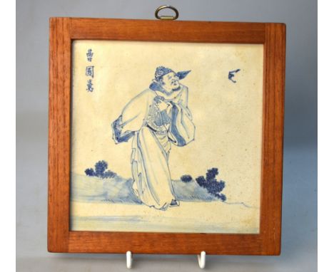 A blue and white tile decorated with a standing scholar, the unglazed reverse marked 'Goh Kim Hah/Fong Ka'; wood frame; overa