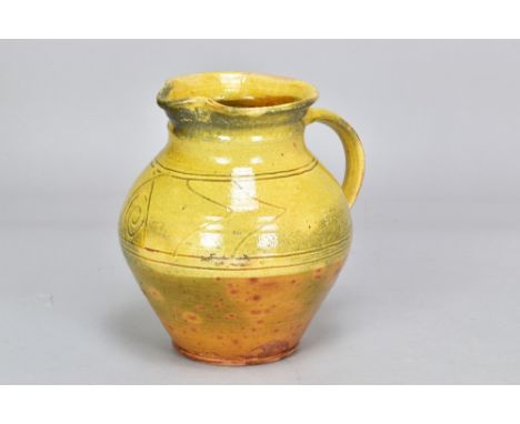 Attributed to MICHAEL CARDEW (1901-1983) for Winchcombe Pottery; a slipware jug with simple sgraffito decoration under a yell