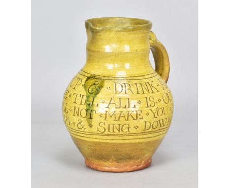 MICHAEL CARDEW (1901-1983) for Leach Pottery; a slipware calligraphic jug with scroll handle covered in pale yellow glaze, in