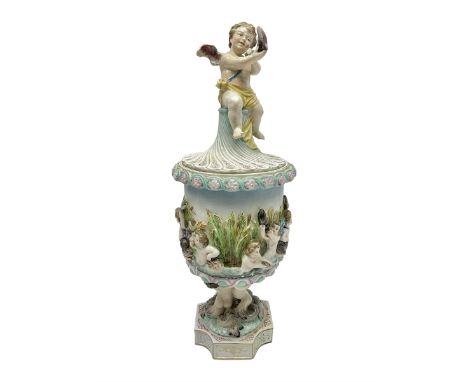 Early 20th century continental pedestal jar with cover, the bowl held aloft by four mermaids and decorated with putti playing