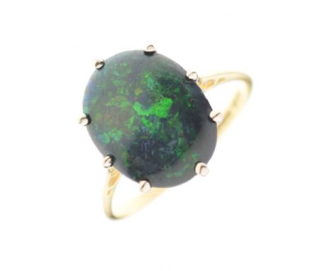 Black opal ring, the yellow mount stamped '18ct' and 'J.M.B', the oval shallow cabochon of green/yellow colour play measuring