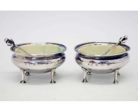 Pair of George V Arts and Crafts planished silver salts of circular tapering form on four elongated legs, and a pair of match