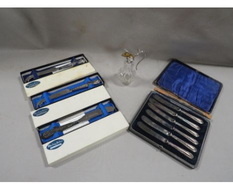 A quantity of boxed silver handled cutlery and a silver topped cut glass bottle/noggin 