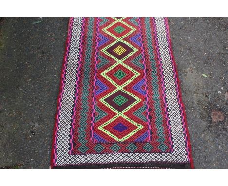 A brightly patterned woollen runner, approx. 230 x 65 cm