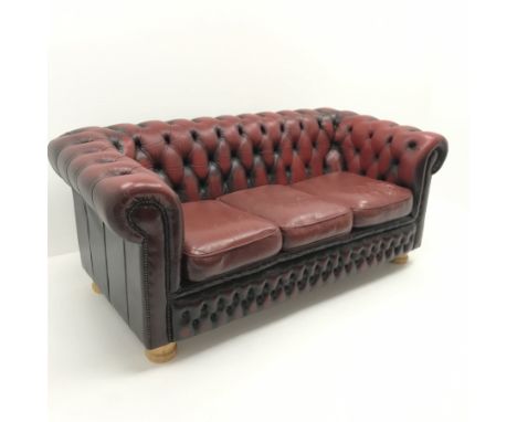 Three seat Chesterfield sofa upholstered in deep buttoned Ox blood leather, turned supports, W185cm - Condition Report Rip to