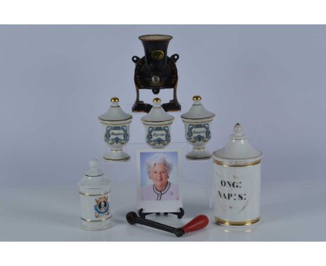 A collection of four continental porcelain drug jars, and a 19th Century example together with a Spong & Co cast iron grinder