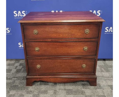 A contemporary mahogany chest of three long drawers, having three  graduated long drawers with brass ring handles over shaped